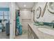 Bright bathroom with a double sink vanity, granite countertop, and decorative nautical-themed mirrors at 16106 6Th E St, Redington Beach, FL 33708