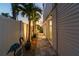 Well-lit walkway featuring lush palm trees and landscaping, leading to an inviting home exterior at 16106 6Th E St, Redington Beach, FL 33708