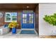 Inviting front entrance with decorative blue door, lush landscaping, and charming exterior details at 16106 6Th E St, Redington Beach, FL 33708