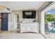 Bright living room with sliding doors to the patio, a tv, and a built-in buffet at 16106 6Th E St, Redington Beach, FL 33708