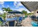 Waterfront patio boasts a seating area with a fire pit, awning, outdoor kitchen, and a private dock with boat access at 16106 6Th E St, Redington Beach, FL 33708