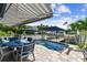 Outdoor patio with private pool, shaded lounge area, waterfront views, and a dock, ideal for relaxation and entertainment at 16106 6Th E St, Redington Beach, FL 33708