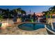 Twilight view of outdoor pool area, boat dock, and tranquil waterfront setting at 16106 6Th E St, Redington Beach, FL 33708