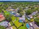 Aerial view of a home with a screened-in pool and lush landscaping in a quiet, tree-lined neighborhood at 1910 Montego Ct, Oldsmar, FL 34677