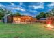 Backyard with lights, fire pit, and a view of screened in pool at 1910 Montego Ct, Oldsmar, FL 34677