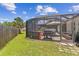A screened enclosure houses a dining area and a pond, set against a lush green lawn and mature trees at 1910 Montego Ct, Oldsmar, FL 34677