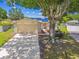 Charming single-story home featuring a large tree, a two-car garage, and a well-manicured lawn at 1910 Montego Ct, Oldsmar, FL 34677