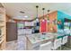 Bright kitchen features a marble countertop island, white cabinets, and modern pendant lighting at 1910 Montego Ct, Oldsmar, FL 34677