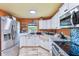 Beautiful kitchen with stainless steel appliances, white cabinets, granite countertops, and tile floors at 1910 Montego Ct, Oldsmar, FL 34677