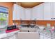 Close-up of white kitchen cabinets and farm sink with granite countertops and stainless steel fixtures at 1910 Montego Ct, Oldsmar, FL 34677