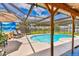 Outdoor screened-in pool area with patio furniture and a tranquil backyard view at 1910 Montego Ct, Oldsmar, FL 34677