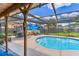 Backyard featuring a screened-in pool with patio furniture and well-maintained landscaping at 1910 Montego Ct, Oldsmar, FL 34677