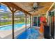 Outdoor pool area with a screened-in patio featuring a ceiling fan and unique decor at 1910 Montego Ct, Oldsmar, FL 34677