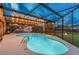 Evening shot of a covered pool with string lights, perfect for a relaxing swim at sunset at 1910 Montego Ct, Oldsmar, FL 34677