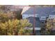 Aerial view of townhome with a gray roof, bordered by green foliage and a two-car garage to the front at 19232 Stone Hedge Dr, Tampa, FL 33647