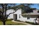 Quaint townhome with a sidewalk, garden, neutral stucco, and trimmed hedges. It's inviting and comfortable at 19232 Stone Hedge Dr, Tampa, FL 33647