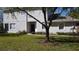 Quaint townhome featuring lush green lawn and colorful floral arrangements leading to a classic dark blue front door at 19232 Stone Hedge Dr, Tampa, FL 33647