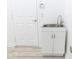 Bright laundry room with a utility sink and storage cabinet at 19232 Stone Hedge Dr, Tampa, FL 33647