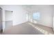 Clean, carpeted bedroom featuring a ceiling fan, closet, and natural light from a window offering a serene view at 19717 Gulf Blvd # V5, Indian Shores, FL 33785