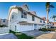Bright daytime view of a charming two-story townhome featuring an attached one-car garage and well-maintained landscaping at 19717 Gulf Blvd # V5, Indian Shores, FL 33785