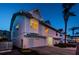 Stunning evening shot of a two-story townhome featuring an attached garage, manicured landscaping, and a welcoming atmosphere at 19717 Gulf Blvd # V5, Indian Shores, FL 33785