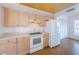 Functional kitchen featuring oak cabinets, white appliances, plenty of counter space, and vinyl floors for ease of maintenance at 19717 Gulf Blvd # V5, Indian Shores, FL 33785