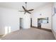 Bright and spacious living room featuring neutral carpet, high ceilings, ceiling fan, and open access to a kitchen at 19717 Gulf Blvd # V5, Indian Shores, FL 33785