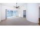 Spacious living room with carpet, fan, and a sliding glass door leading to a balcony with plenty of natural light at 19717 Gulf Blvd # V5, Indian Shores, FL 33785