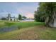 A partial view of the home's backyard, including a pond and the fences of adjacent properties at 208 Oakwood Blvd, Oldsmar, FL 34677