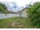 View of the home's backyard, showing a white fence and the back of the home at 208 Oakwood Blvd, Oldsmar, FL 34677