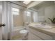 Clean bathroom featuring a shower-tub combination with a white shower curtain, a vanity with a sink, and natural light at 208 Oakwood Blvd, Oldsmar, FL 34677