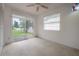 Bedroom with a ceiling fan, a sliding glass door leading to a patio, and a large window for natural light at 208 Oakwood Blvd, Oldsmar, FL 34677