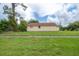 View of the exterior side of the yellow home with a visible roof against a blue sky at 208 Oakwood Blvd, Oldsmar, FL 34677