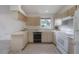 Close-up of the kitchen featuring light wood cabinets, white appliances, and a stainless steel sink at 208 Oakwood Blvd, Oldsmar, FL 34677