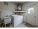 This laundry room features a washing machine, dryer, sink, and shelving at 208 Oakwood Blvd, Oldsmar, FL 34677