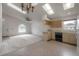 Bright living room featuring a skylight, ceiling fan, and an arched window with views of the front yard, seamlessly connected to the kitchen at 208 Oakwood Blvd, Oldsmar, FL 34677