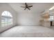 Bright and airy living room with vaulted ceilings, a ceiling fan, and a large arched window offering ample natural light at 208 Oakwood Blvd, Oldsmar, FL 34677