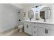 Modern bathroom with double vanity, white cabinets, and a walk-in shower with decorative tile at 2272 Adam Ct, Palm Harbor, FL 34683