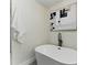 Close-up of modern white soaking tub with black hardware and neutral wall art at 2272 Adam Ct, Palm Harbor, FL 34683