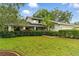 Inviting two-story home boasting a lush green lawn, mature landscaping, and a classic architectural design at 2272 Adam Ct, Palm Harbor, FL 34683