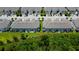 Aerial view of townhomes with back porches; view also shows proximity to green space at 2435 Foggy Creek Cir, Clearwater, FL 33764
