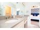 Bright bathroom featuring dual sinks with granite countertops and a door leading to bedroom at 2435 Foggy Creek Cir, Clearwater, FL 33764