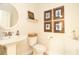 Half bathroom with pedestal sink, decorative wall art, and a modern toilet at 2435 Foggy Creek Cir, Clearwater, FL 33764