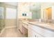Bright bathroom with dual sinks, granite countertops, and a glass-enclosed shower at 2435 Foggy Creek Cir, Clearwater, FL 33764