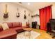 Cozy living room featuring a plush red sectional sofa, unique decor, and hardwood floors at 2435 Foggy Creek Cir, Clearwater, FL 33764