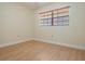 Cozy bedroom featuring wood-look flooring and a large window with blinds at 2465 Northside Dr # 605, Clearwater, FL 33761
