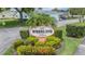 Woodland Villas community sign surrounded by lush greenery, welcoming residents and visitors alike at 2465 Northside Dr # 605, Clearwater, FL 33761