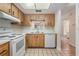 Well-lit kitchen with white appliances, wood cabinets, tile floors, and bright countertops at 2465 Northside Dr # 605, Clearwater, FL 33761