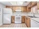 Bright kitchen featuring wood cabinetry, tile floors, white appliances, and ample counter space at 2465 Northside Dr # 605, Clearwater, FL 33761
