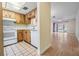 A view of the kitchen with white appliances and wood cabinets, open to the living room at 2465 Northside Dr # 605, Clearwater, FL 33761